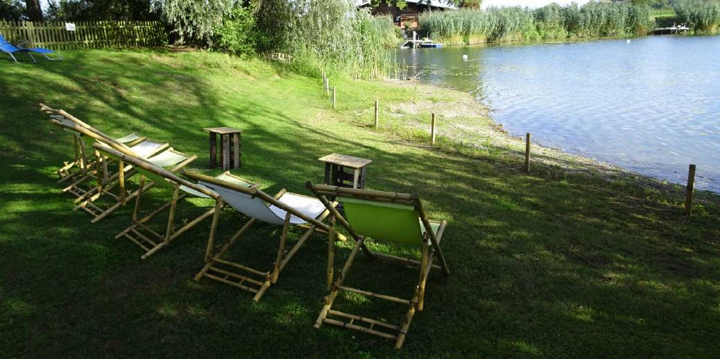 Am Weiher stehen Liegestühle zum entspannen.